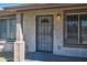 Close-up of the front door area, with security bars and weathered features, needs some renovation at 4870 W Almeria Rd, Phoenix, AZ 85035
