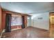 View of the living room with hardwood floors, with curtains and front door, in need of renovation at 4870 W Almeria Rd, Phoenix, AZ 85035
