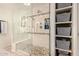 Bathroom featuring a large glass enclosed shower with built-in shelving and pebble floor at 4915 W Libby St, Glendale, AZ 85308