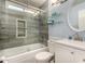 Modern bathroom featuring tiled walls, glass shower door, a white vanity, and a round mirror at 4915 W Libby St, Glendale, AZ 85308