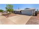 Single-story home with a light blue exterior, two-car garage, and desert landscaping in the front yard at 4915 W Libby St, Glendale, AZ 85308