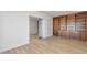Bedroom featuring hardwood floors, a closet with mirrored doors, and a built in bookcase at 511 E Calavar Rd, Phoenix, AZ 85022