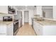 Modern kitchen with stainless steel appliances, granite counters, and white cabinets at 511 E Calavar Rd, Phoenix, AZ 85022