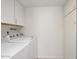 Bright laundry area with modern, white appliances and storage cabinets for convenience at 511 E Calavar Rd, Phoenix, AZ 85022