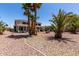 Spacious backyard view featuring patio, lush landscaping, several mature palm trees, and decorative rock at 5322 N Oro Vista Ct, Litchfield Park, AZ 85340