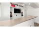 Fun bar area with mounted TV, sports memorabilia, bar top and shelves at 5322 N Oro Vista Ct, Litchfield Park, AZ 85340