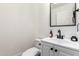 Stylish half bathroom featuring a modern vanity, black fixtures, and clean white finishes at 5322 N Oro Vista Ct, Litchfield Park, AZ 85340