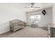 Cozy room with carpet floors, ceiling fan, window, crib, and decorative flag at 5322 N Oro Vista Ct, Litchfield Park, AZ 85340