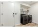 Functional laundry room with modern washer and dryer, and storage shelves at 5322 N Oro Vista Ct, Litchfield Park, AZ 85340