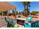 Outdoor patio featuring a pergola, landscaping, lounge chairs, and fire pit table at 5322 N Oro Vista Ct, Litchfield Park, AZ 85340
