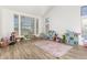 A sunlit playroom features large windows, wood-look floors, and ample space for activities at 5322 N Oro Vista Ct, Litchfield Park, AZ 85340