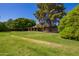 Lush green backyard with mature trees surrounding a single-story home at 6637 W Pershing Ave, Glendale, AZ 85304