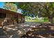 Brick patio with seating surrounded by a large yard and mature trees at 6637 W Pershing Ave, Glendale, AZ 85304