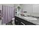 A bathroom features a vanity with solid surface countertop, and decorative shower curtain at 7812 W Payson Rd, Phoenix, AZ 85043