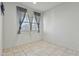 Bright, empty bedroom with tile flooring and a large window at 7812 W Payson Rd, Phoenix, AZ 85043