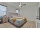 Bedroom with soft carpet, a ceiling fan, and a tufted gray headboard at 7812 W Payson Rd, Phoenix, AZ 85043