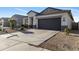 Wide driveway leads to a two-car garage of a modern home with desert landscaping at 7812 W Payson Rd, Phoenix, AZ 85043