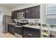 The kitchen is equipped with modern appliances, dark wood cabinets, and granite countertops at 7812 W Payson Rd, Phoenix, AZ 85043