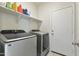 Laundry room featuring updated washer and dryer, shelving for storage, and access to exterior at 7812 W Payson Rd, Phoenix, AZ 85043