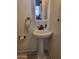 Small pedestal sink and fixtures with a decorative mirror and neutral wall color at 815 N Hayden Rd # B4, Scottsdale, AZ 85257