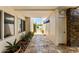 Covered patio with decorative plants and stone flooring leading to an outdoor gate at 8637 E Via De La Escuela --, Scottsdale, AZ 85258