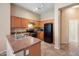 Eat-in kitchen featuring wood cabinets, modern appliances, and tile flooring at 9233 E Neville Ave # 1125, Mesa, AZ 85209