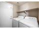 Practical laundry room equipped with a washer, dryer, and a shelf for storage at 9233 E Neville Ave # 1125, Mesa, AZ 85209