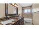 Bright bathroom featuring double sinks with granite counters and a tiled shower and bathtub enclosure at 1001 W Northern Ave, Phoenix, AZ 85021