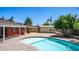 Backyard showing an inground pool, exterior of the house, and two utility sheds at 1001 W Northern Ave, Phoenix, AZ 85021