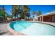 Backyard with an inground pool surrounded by a brick patio, desert landscaping, and palm trees at 1001 W Northern Ave, Phoenix, AZ 85021