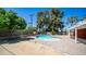 Backyard with an inground pool surrounded by a brick patio, trees, and desert landscaping at 1001 W Northern Ave, Phoenix, AZ 85021