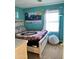 Bright bedroom with a wooden frame bed, and a cozy beanbag in front of a window at 11867 W Alvarado Rd, Avondale, AZ 85392