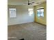Spacious living room with neutral carpet, ceiling fan and window with bright, natural light at 11867 W Alvarado Rd, Avondale, AZ 85392