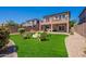 A beautiful backyard with a fire pit, adirondack chairs, and lush green lawn at 1187 E Frances Ln, Gilbert, AZ 85295