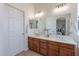 Bathroom featuring double sinks, wood vanity and large mirror for a spacious feel at 1187 E Frances Ln, Gilbert, AZ 85295