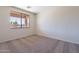 Bright bedroom featuring plush carpet, a window overlooking the yard, and neutral paint at 1187 E Frances Ln, Gilbert, AZ 85295