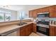 Well-lit kitchen features stainless steel appliances, wood cabinets, and tile flooring at 1187 E Frances Ln, Gilbert, AZ 85295