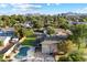 Beautiful aerial view of a home with a backyard pool, lush greenery, and mountain views at 13411 N 50Th St, Scottsdale, AZ 85254