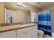 Bathroom with granite counters, white cabinets, and a tub with blue shower curtain offering lots of space at 13411 N 50Th St, Scottsdale, AZ 85254