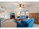 Cozy living room featuring plush blue sofas, a ceiling fan, and a television for relaxed living at 13411 N 50Th St, Scottsdale, AZ 85254