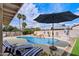 Inviting backyard pool area with lounge chairs, rock waterfall feature, and ample patio space at 13411 N 50Th St, Scottsdale, AZ 85254