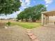 Expansive backyard with lush green lawn, mature trees, and a covered patio, ideal for outdoor living at 1377 W Park Ave, Gilbert, AZ 85233