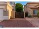 Exterior side view of property, desert landscaping, wooden gate, and two-story home at 1377 W Park Ave, Gilbert, AZ 85233