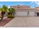 A three car garage with a large driveway and desert landscaping at 1377 W Park Ave, Gilbert, AZ 85233