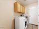 Functional laundry room with modern washer and dryer, complemented by ample cabinet storage at 1377 W Park Ave, Gilbert, AZ 85233
