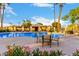 Community pool area with tables, lounge chairs and palm trees, perfect for relaxation and recreation at 1377 W Park Ave, Gilbert, AZ 85233