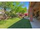 Expansive backyard with synthetic grass, lush landscaping, and outdoor seating area with mountain views at 13914 E Laurel Ln, Scottsdale, AZ 85259