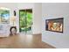 Bright living room featuring a modern fireplace, wood floors, and a sliding glass door to the outdoor space at 13914 E Laurel Ln, Scottsdale, AZ 85259