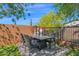 An outdoor dining table with comfortable chairs, potted plants, and a shade tree at 13914 E Laurel Ln, Scottsdale, AZ 85259