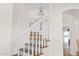 Staircase with decorative tile risers, white banister, and wrought iron chandelier at 13914 E Laurel Ln, Scottsdale, AZ 85259